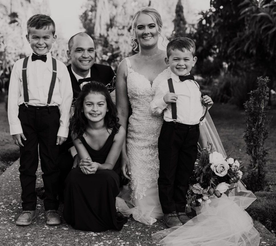 Josh Te Rauna with his wife and three children, in a black-and-white family portrait.